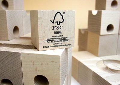 Klocek drewniany z logotypem FSC, czyli Forest Stewardship Council.